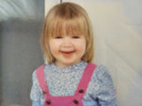 Young girl in overalls smiling