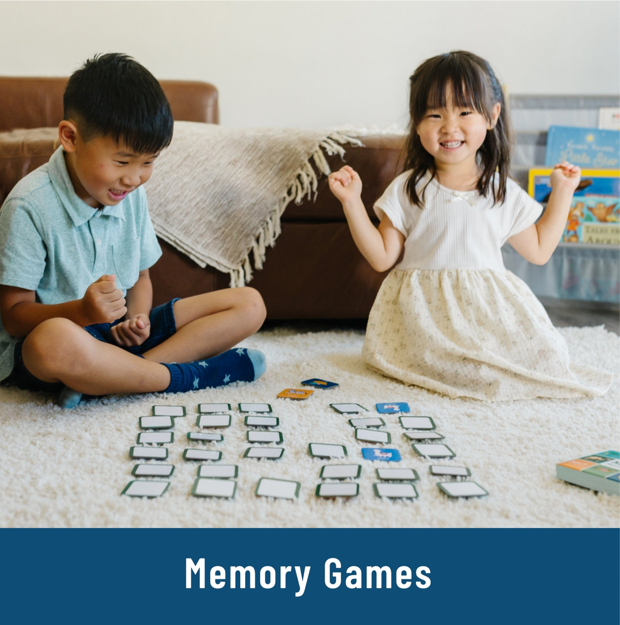 little boy and little girl sitting on white rug with memory cards flipped upside down, little girl showing excitement