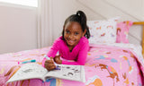 Girl with coloring book, laying on a bed with Horses bedding