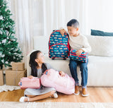 Boy and Girl smiling at each other while holding Wildkin duffel bag, toiletry bags, and rolling luggage