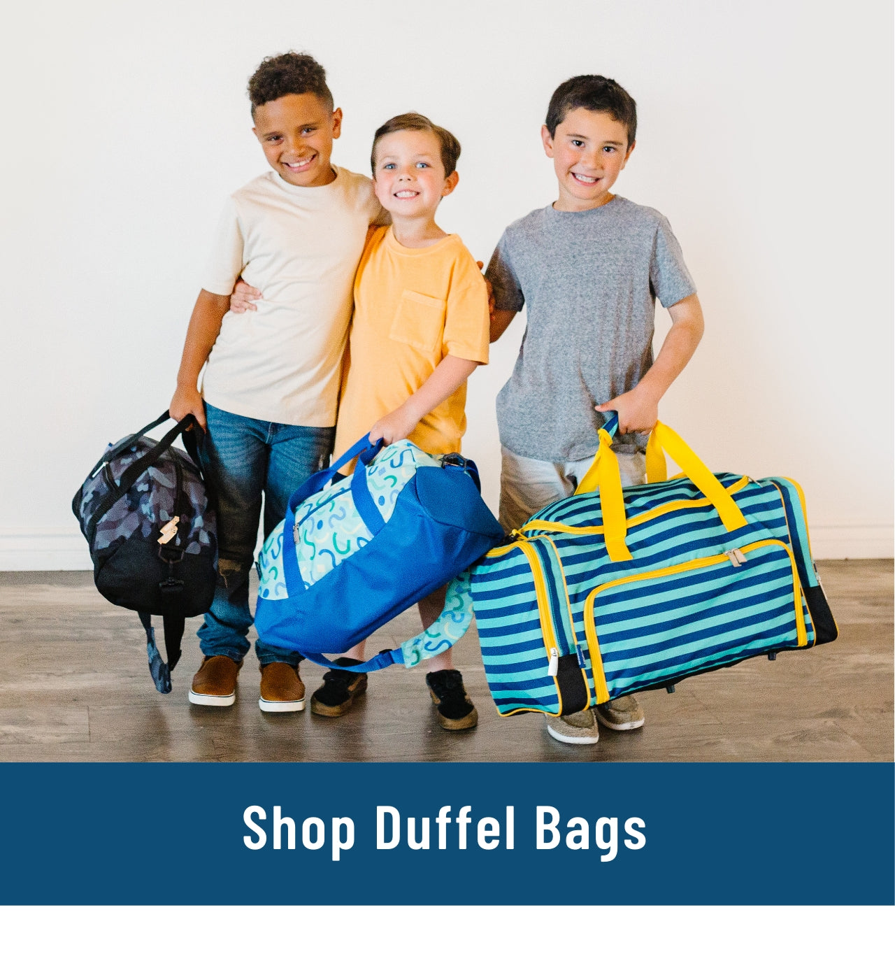 Image of 3 boys standing and holding 3 duffel bags with the patterns Black Camo, Confetti Blue, and Blue Stripes. Link to shop Duffel Bags