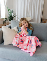 Girl on couch snuggling with Magical Unicorn Plush Blanket