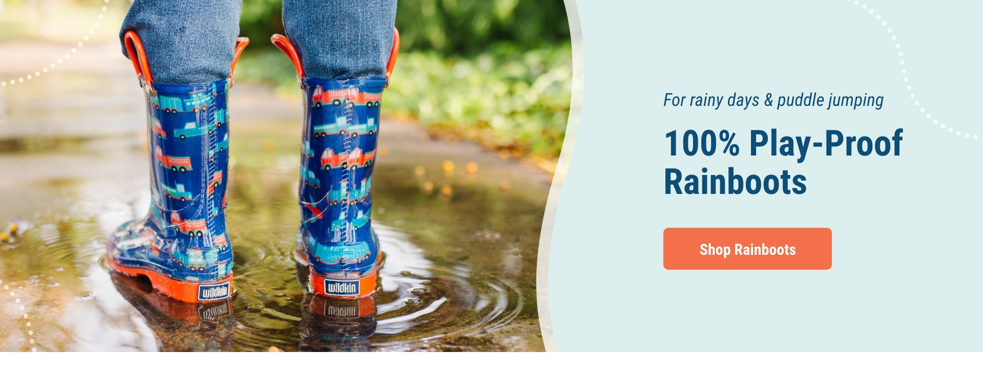 Image of boy wearing transportation boots standing in a puddle of water. For rainy days and puddle jumping. 100% play-proof rainboots. Link to shop rainboots
