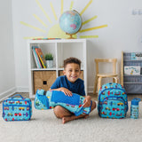 Smiling child seated on a rug with vehicle-pattern backpack, nap mat, lunch bag, and water bottle.